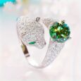 Silver ring with green gemstone and panther design.