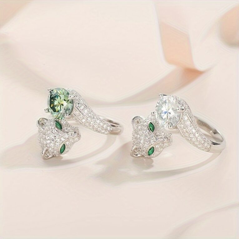 Two silver rings with sparkling gemstones and emerald eyes